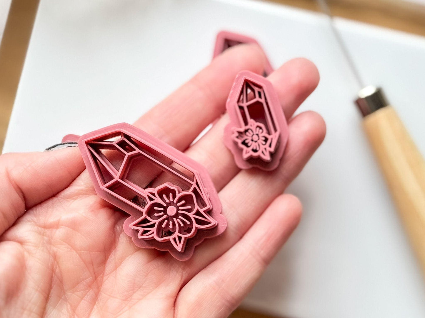 Pointed crystal clay cutter with floral element in hand