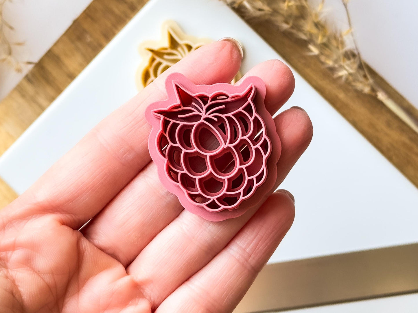 close up of raspberry berry cutter in hand