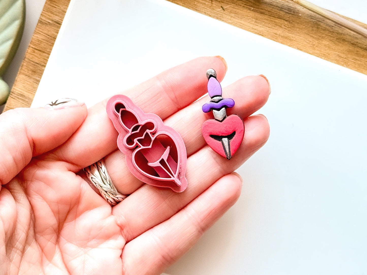 Heartbreak clay cutter with heart shape being pierced by a dagger.