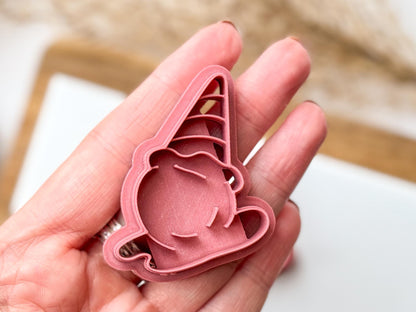 Close up of ice cream clay cutter being held in a hand for scale