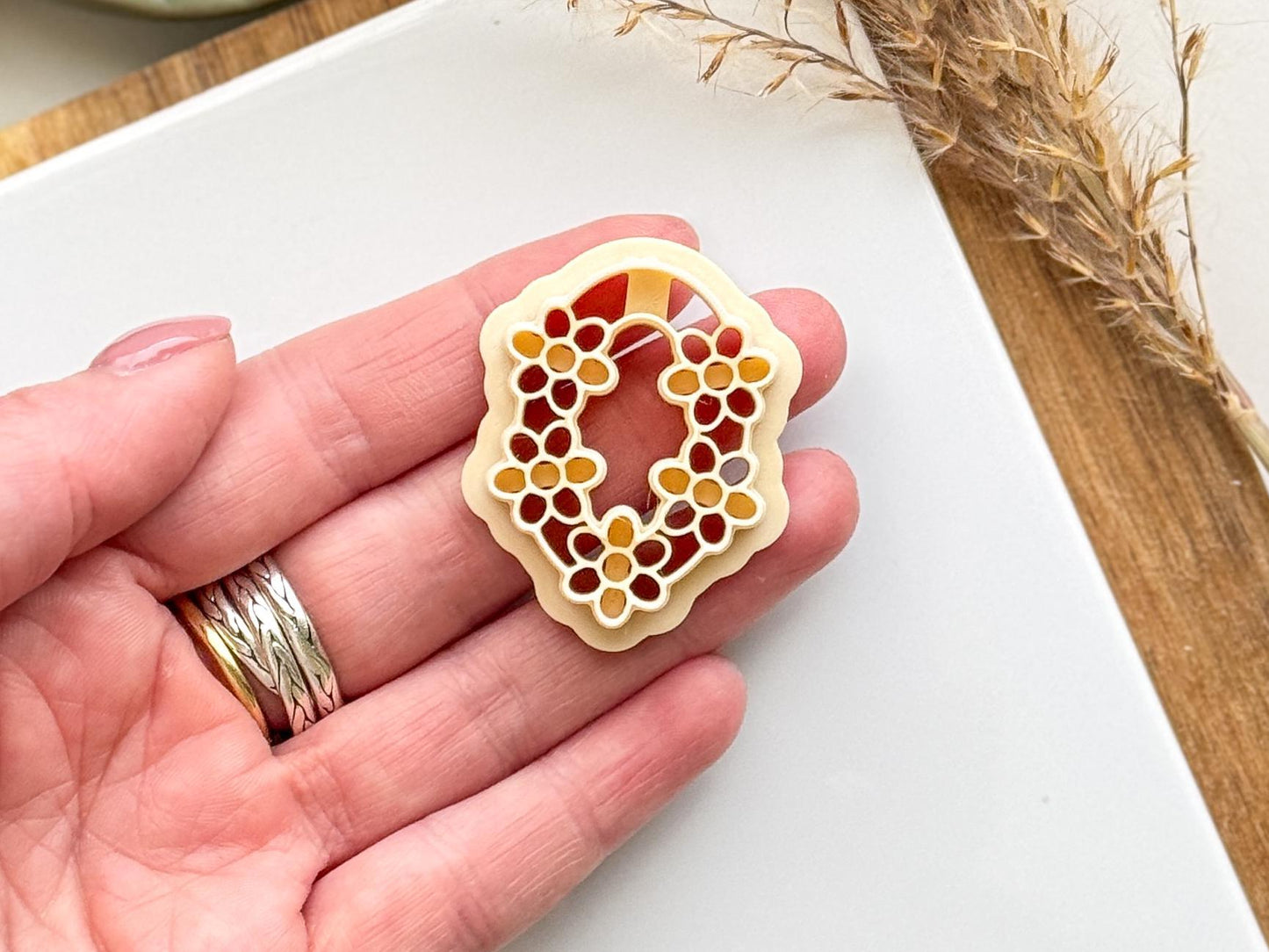 Beige clay cutter in hand for scale