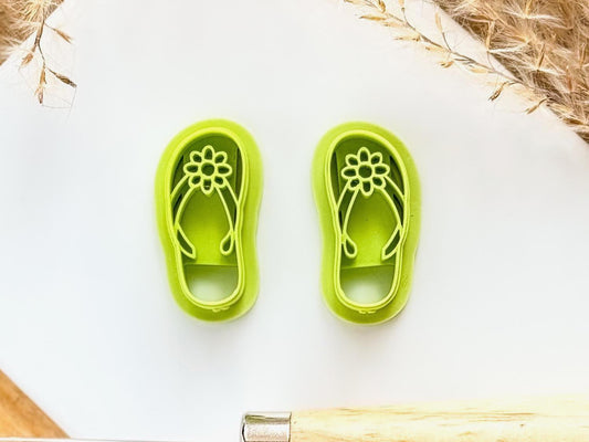 mirrored pair of flip flop sandal clay cutters with straps and flower detail in bright green