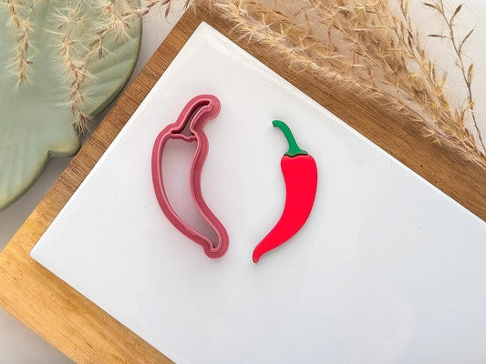 Chili pepper clay cutter in pink plastic with red and green cut out polymer clay