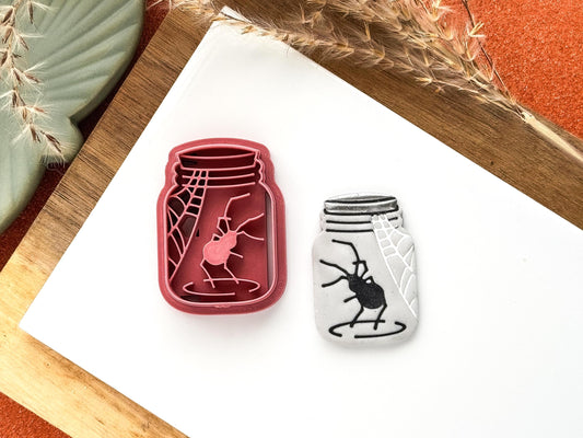 Clay cutter in the shape of a jar with spider and web stamp details