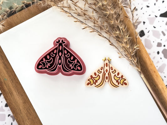 Boho sytle moth polymer clay cutter in dark pink colour with beige cut out clay shape