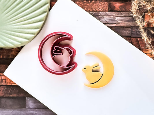 Clay cutter and polymer clay sample cut out. Crescent moon with rabbit shape on a white baking tile.