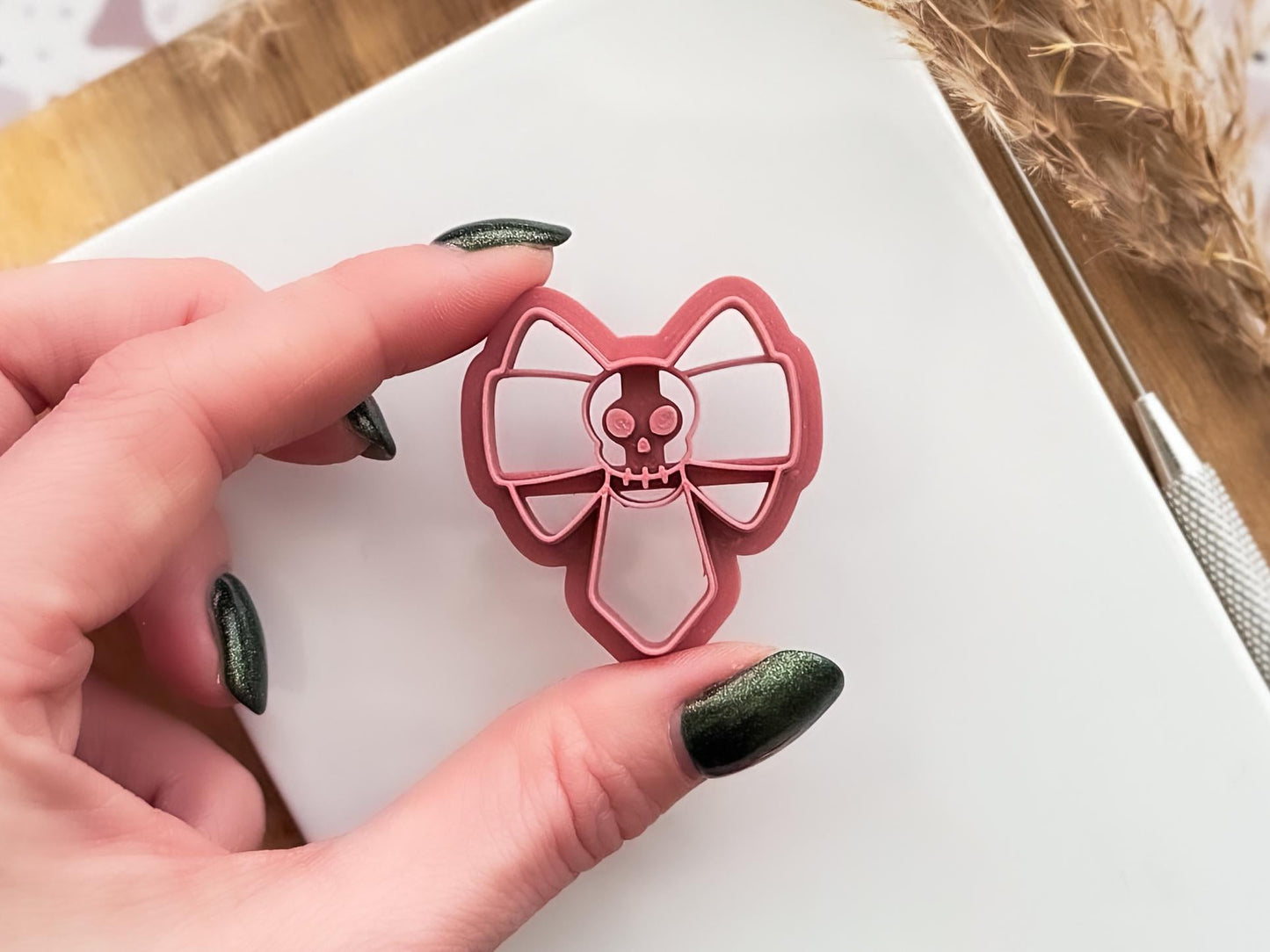 gothic skull bow clay cutter beinng held for close up