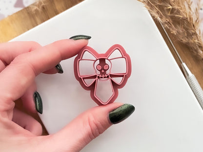 gothic skull bow clay cutter beinng held for close up