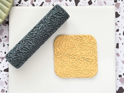 Vintage vines and leaf texture rolling tool for polymer clay with a beige sample on a white tile