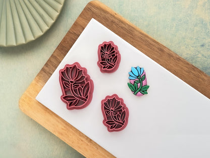 Contains 3 oval shaped flower cutters, the flower if closed and facing skyward with along stem and several leaves.