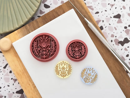 circular boho flower clay cutters in dark pink with yellow and blue polymer clay cut out samples painted with gold.