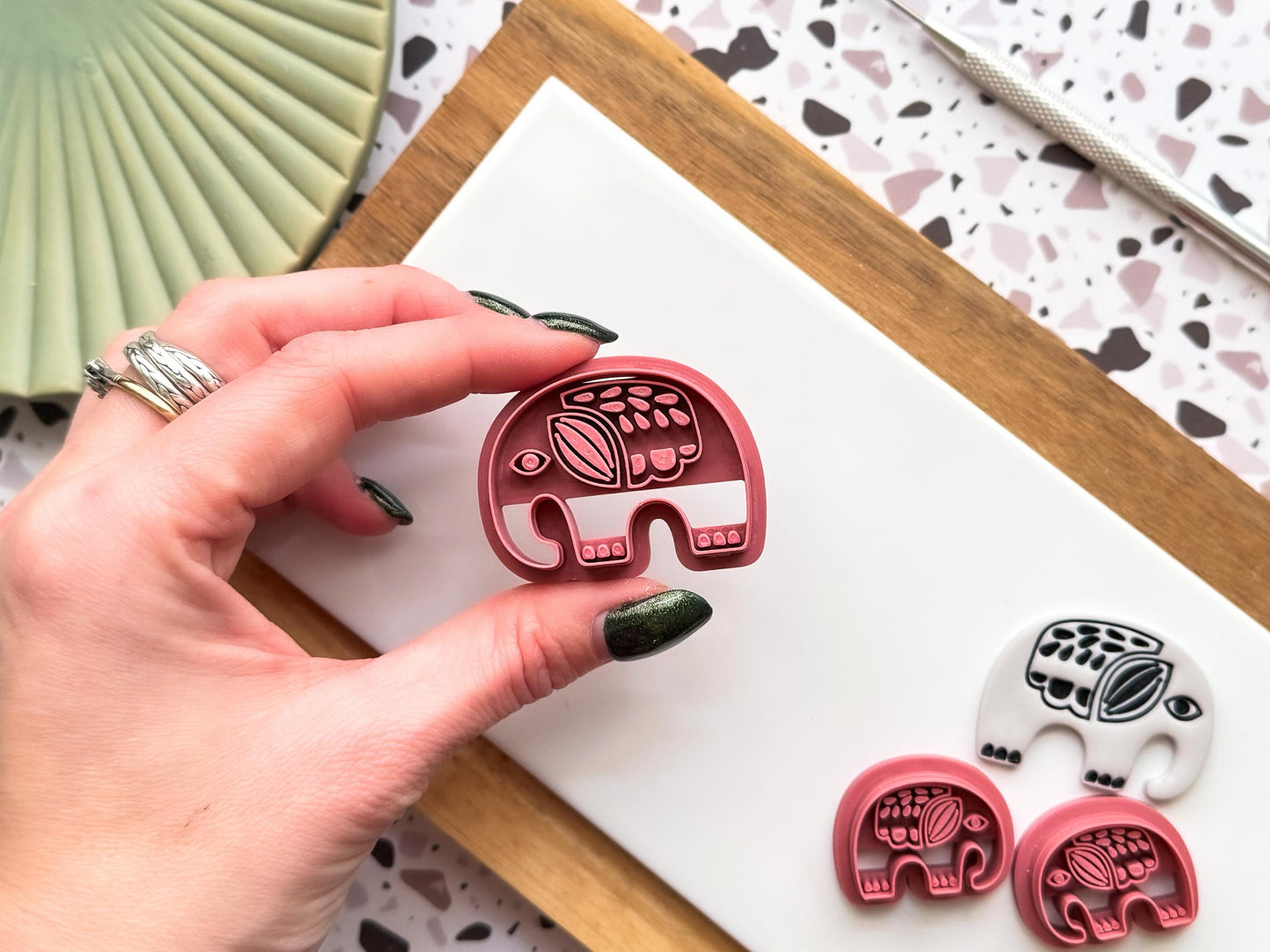bohemian elephant animal polymer clay and fondant cutter being held between the fingers to showcase air flow to prevent clay getting stuck.