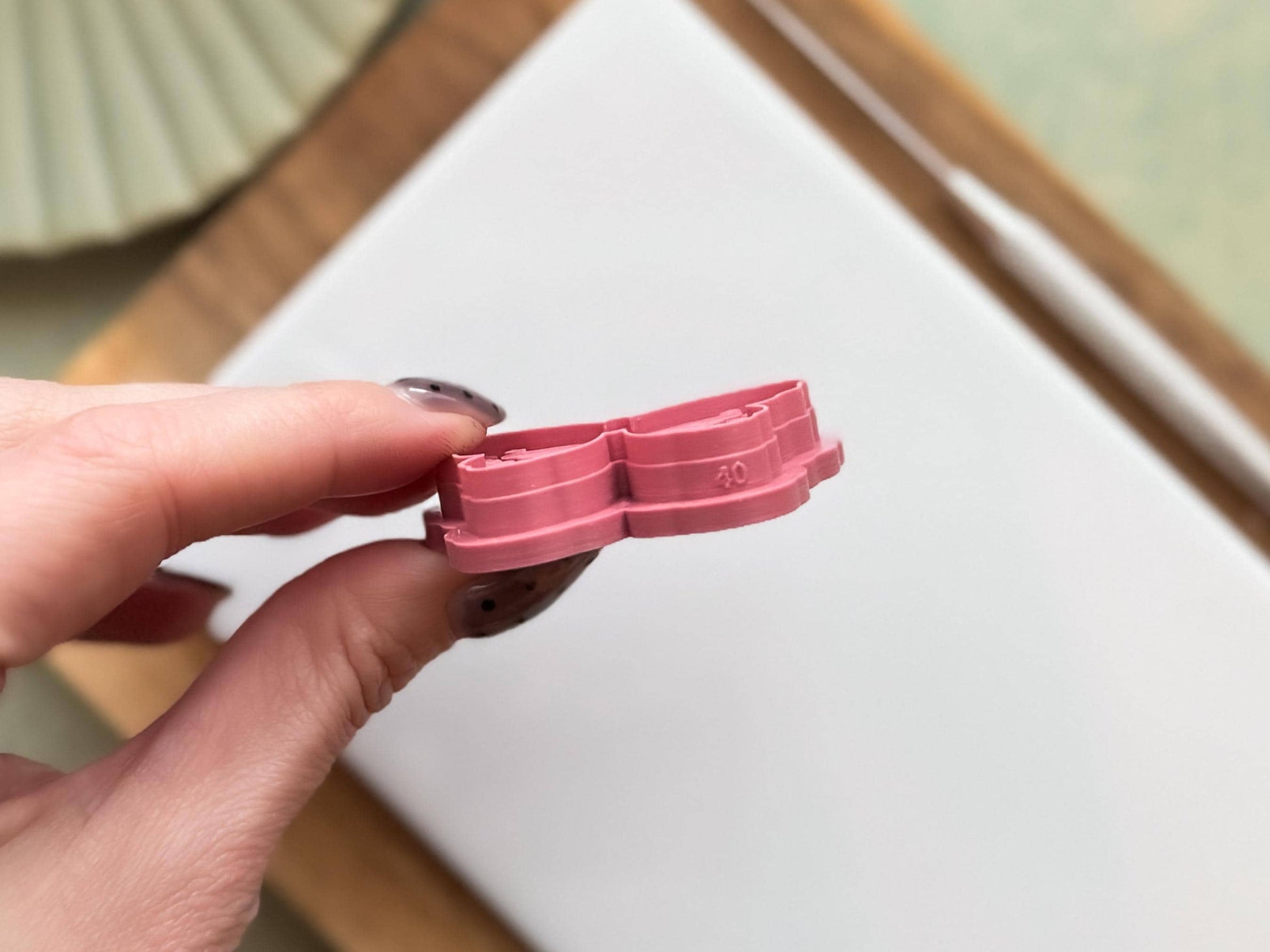 Side view of butterfly clay cutter showing size and sharp cutting edge. The cutter us is pink and 4cm.