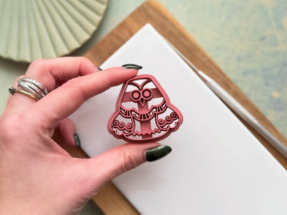 4 cm whimsical owl clay cutter being held between two fingers to demonstrate air flow to prevent the clay from sticking during use.