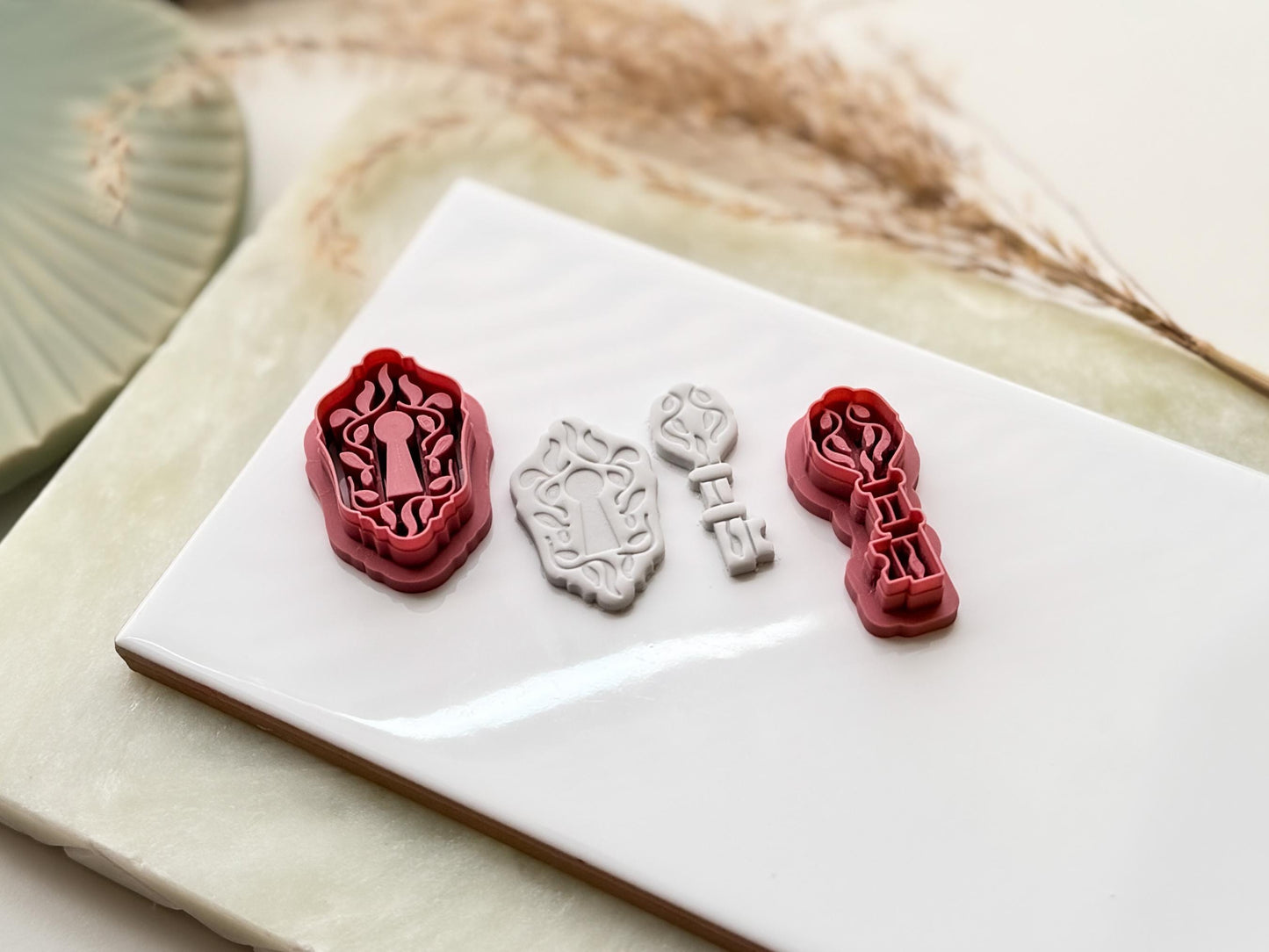 Tilted view of key and lock clay earring cutters and gray polymer clay cut out samples to show detail depth