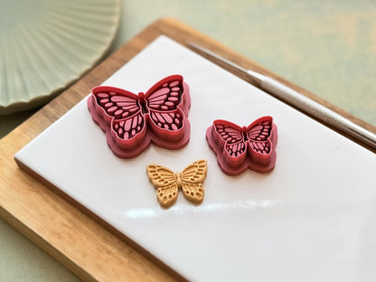 Side view of small and large butterfly clay cutters and polymer clay cut out to show depth of stamp details.