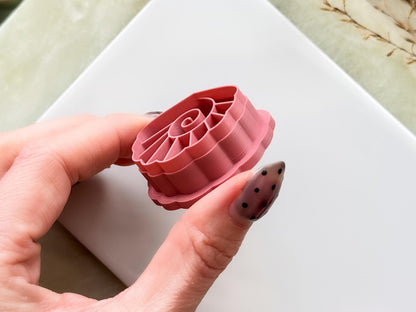 Close up side-view of a shell shaped cutter for polymer clay and fondant. The sharp cutting edge is clearly displayed.