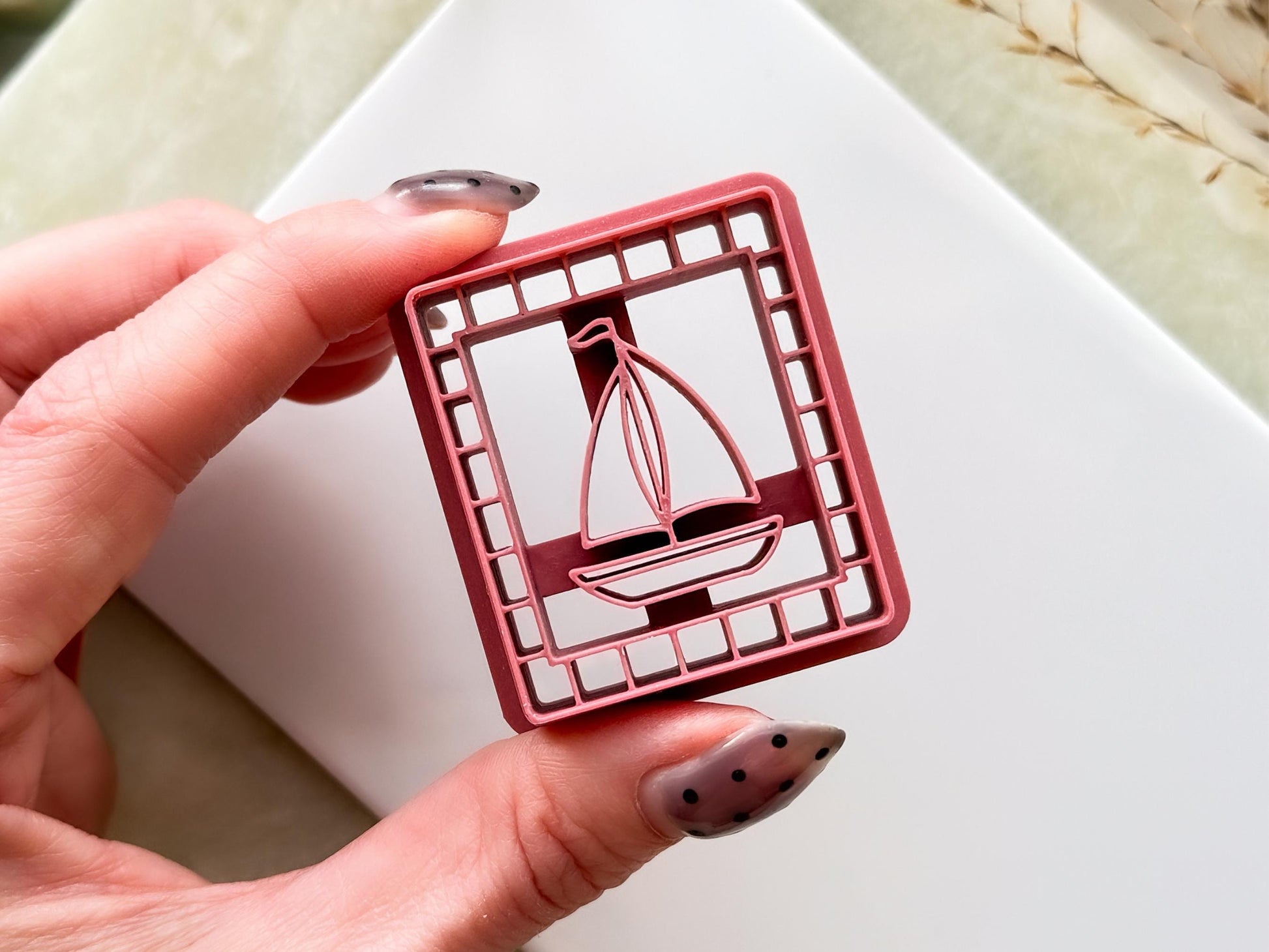 Square craft cutter with lined border and sail boat motif stamp.