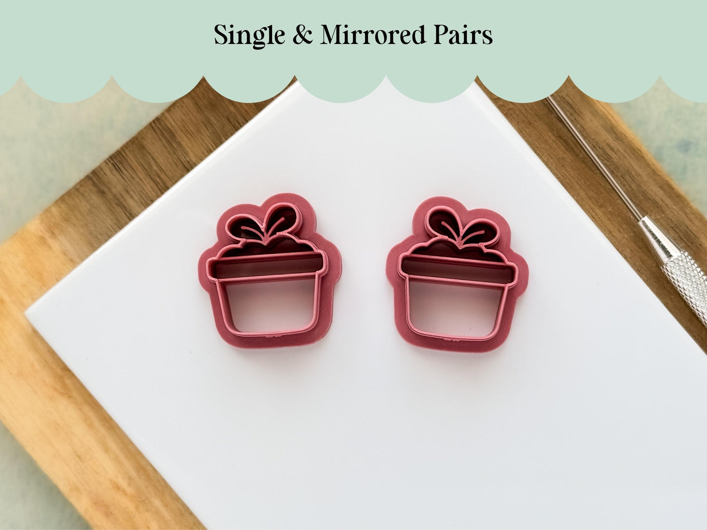 Set of mirrored flower pot clay and fondant cutters with leaf details on a white tile.