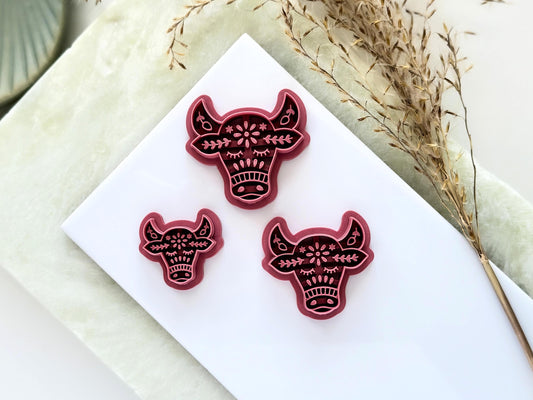 3 horned cow clay cutters with nordic style imprint patterns. This image features a single large cutter and smaller mirrored pairs for earring and jewellery making