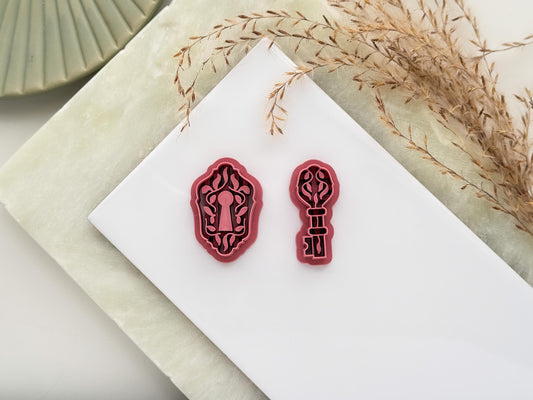 Botanical lock and key shaped polymer clay cutters for earring, jewellery and accessory making. Both shapes feature ornate leaf imprint details. The cutters are pink on a white background.