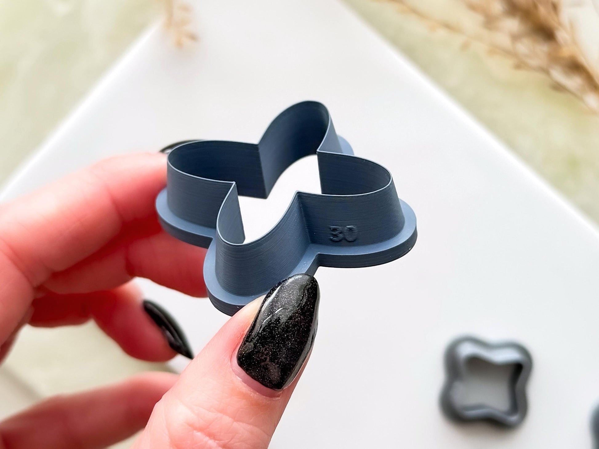 Side view of an X shaped clay cutter with rounded corners