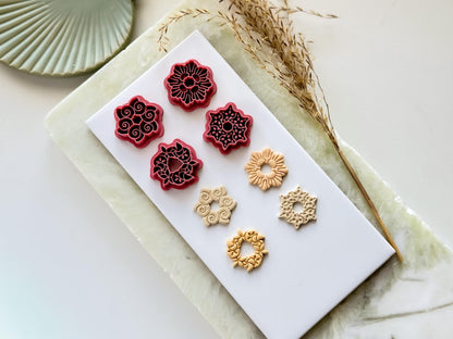 Summer shell clay cutter set, 4 ring shaped cutters with cut out middle featuring seashell, clam shell, sand dollar and starfish designs. Next to them is 4 polymer clay cut out samples.