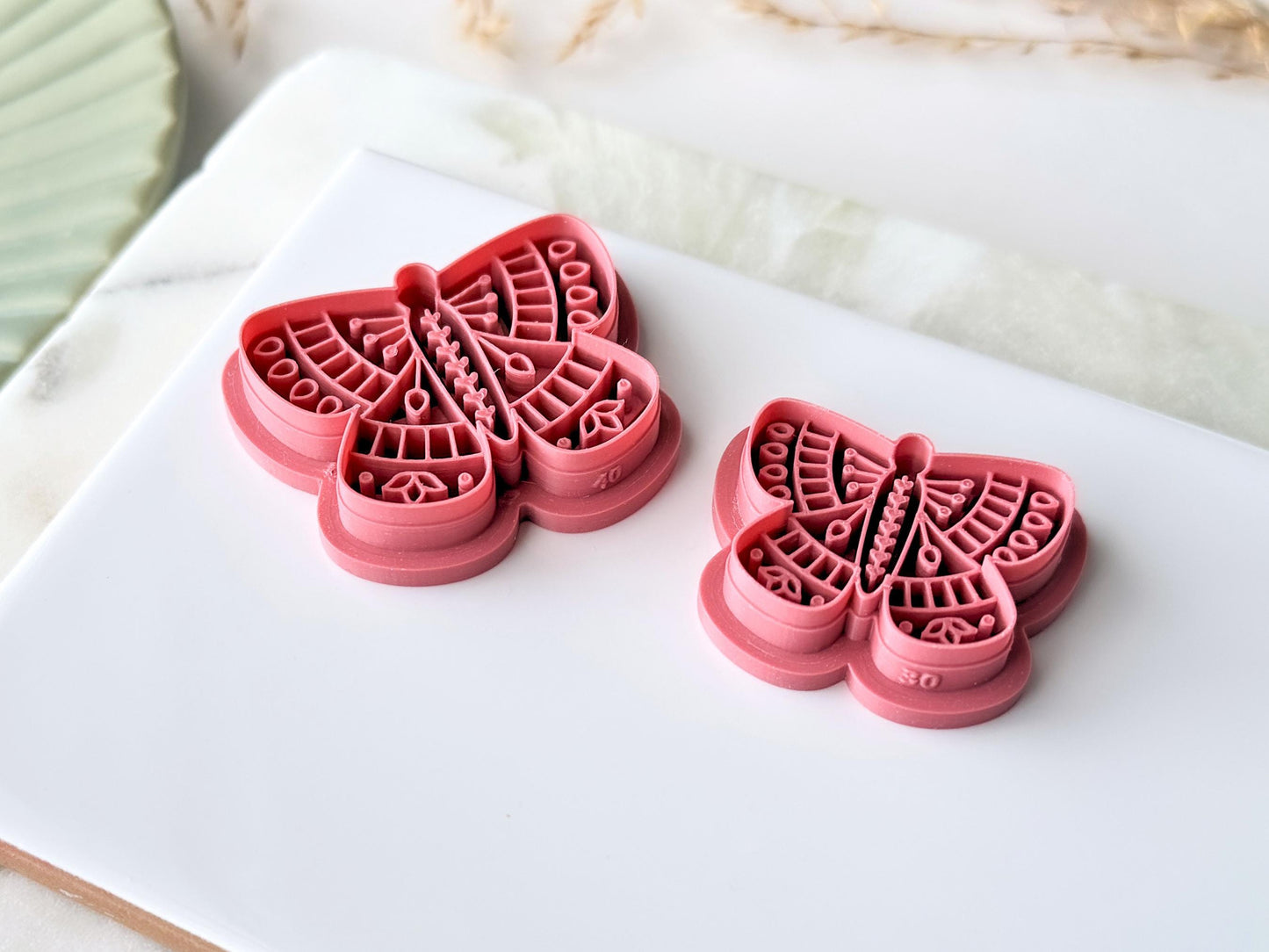 Side view of folk art butterfly clay cutters showing the stmap detail height and sharp cutting edge. 