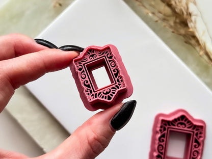 Rectangle ornate frame clay cutter being held in a hand to highight the decorative stamp details