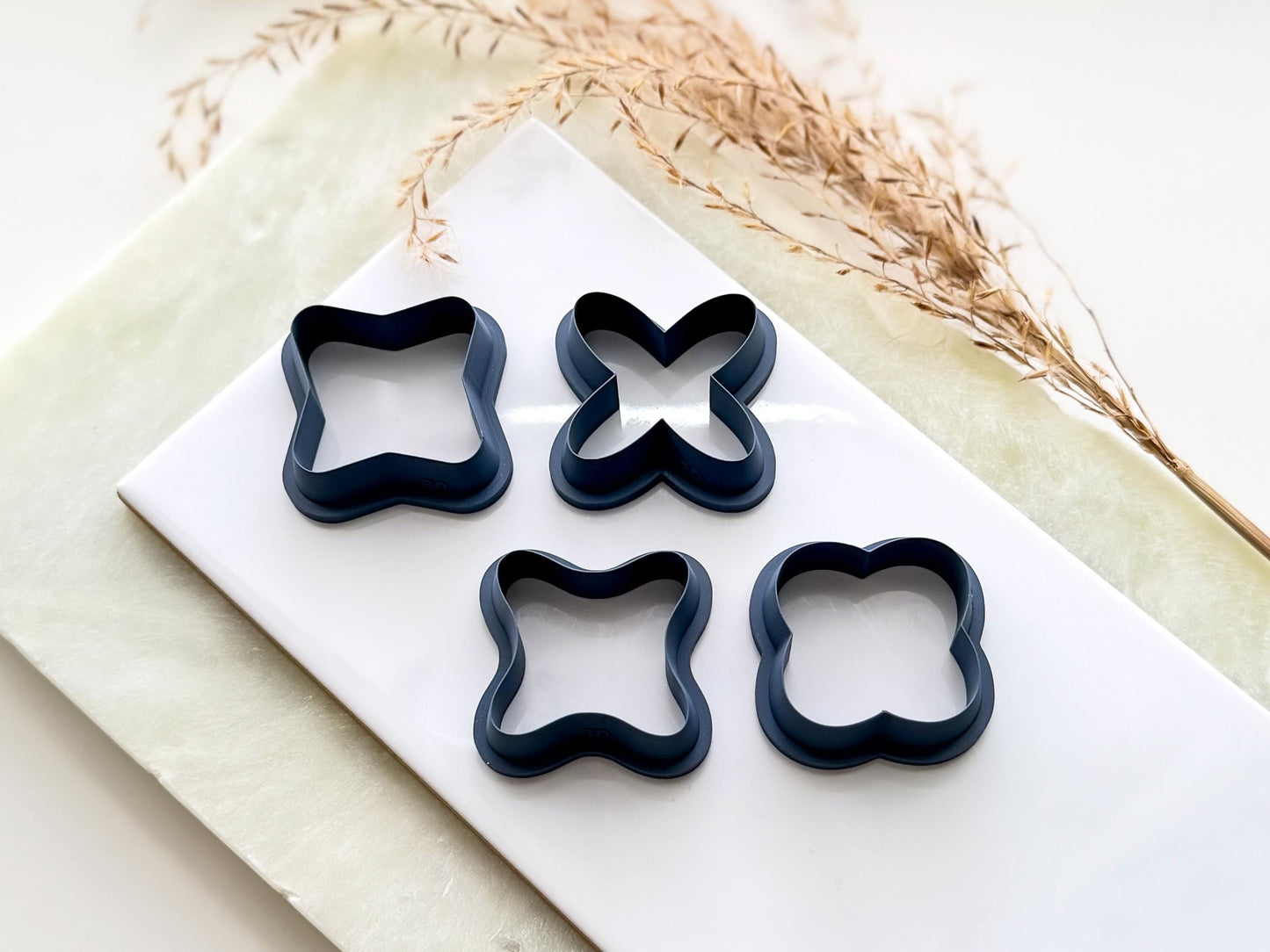 Four cross shaped clay cutters, outline shape only. the cutters feature a bevelled edge and very sharp cutting edge. Each cutter is a different x shape.