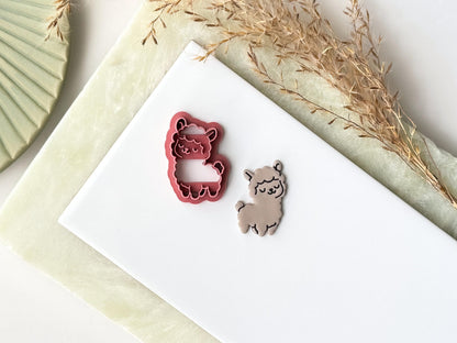 Cute Llama clay cutter and llama polymer clay cut out on a tile. This cutter is designed for use with polymer clay, ceramic clay and silver clay. It is also available in a food safe material for fondant use.