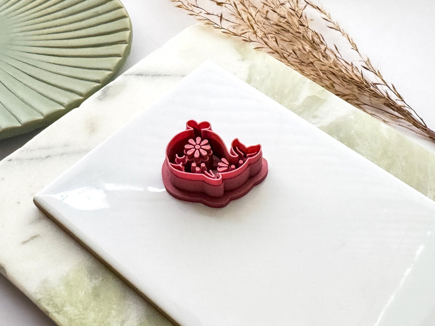 Whale polymer clay cutter with floral embossed design on a white tile. UK-made clay tool for earrings, jewellery, fondant and craft projects.