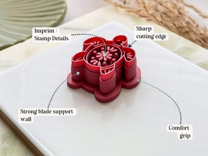 Side view of a sea turtle-shaped polymer clay cutter in dark pink PLA, highlighting the sharp cutting edge, reinforced support wall, embossed stamp details and comfortable grip handle. Displayed on a white tile with decorative dried grasses.