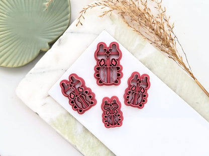 Various sizes of beetle shaped polymer clay cutter arranged on a white tile