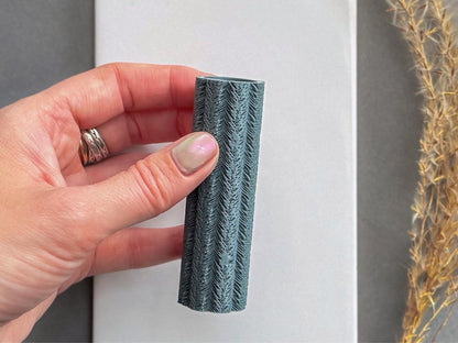 Feather texture roller held in hand to show size for polymer clay and ceramic clay projects.