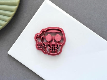 Skull mug polymer clay cutter featuring intricate stamp details and a mug handle silhouette. Displayed on a white tile with a neutral background for a clear product view.