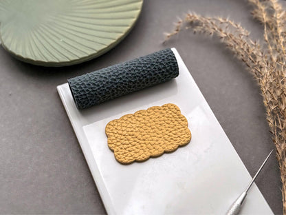 Leather grain texture roller for polymer clay shown with realistic leather effect clay impression.