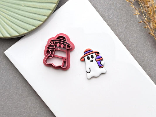 Cute summer ghost polymer clay cutter displayed beside a finished ghost earring with a striped smoothie cup.