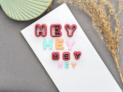 Uppercase and lowercase alphabet polymer clay letter cutters displayed with matching pastel clay letters in multiple sizes for scale comparison.