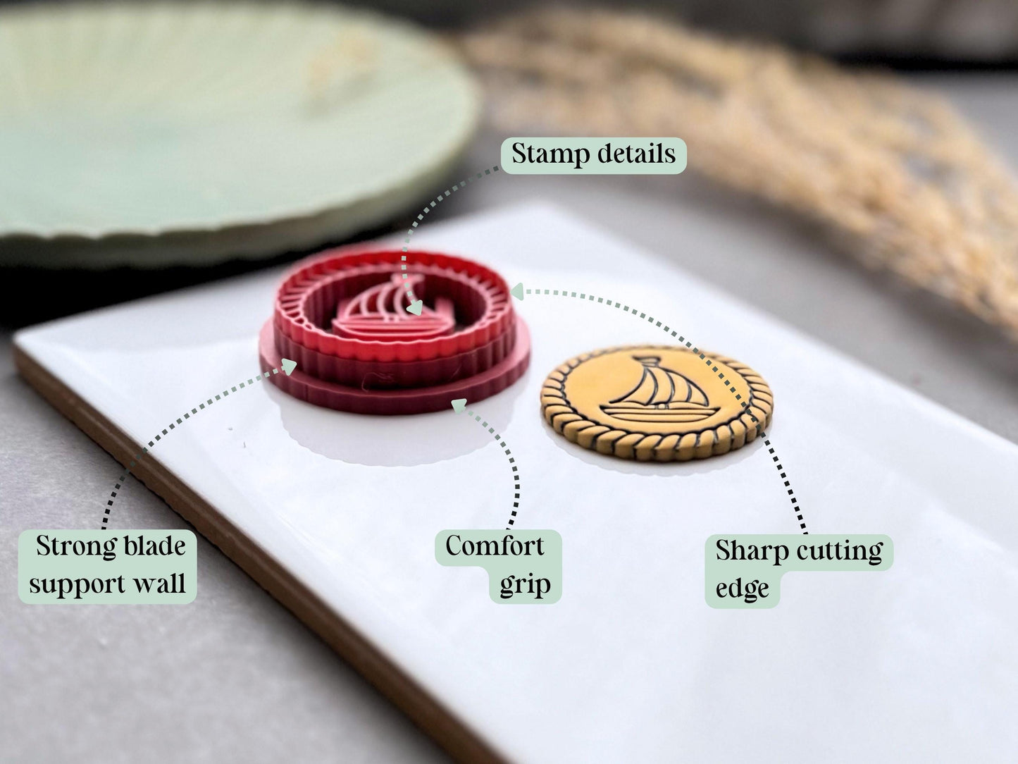 Polymer clay cutter with annotated features, highlighting the detailed stamp imprint, sharp cutting edge, strong blade support wall and comfortable grip for clean, precise clay cuts.