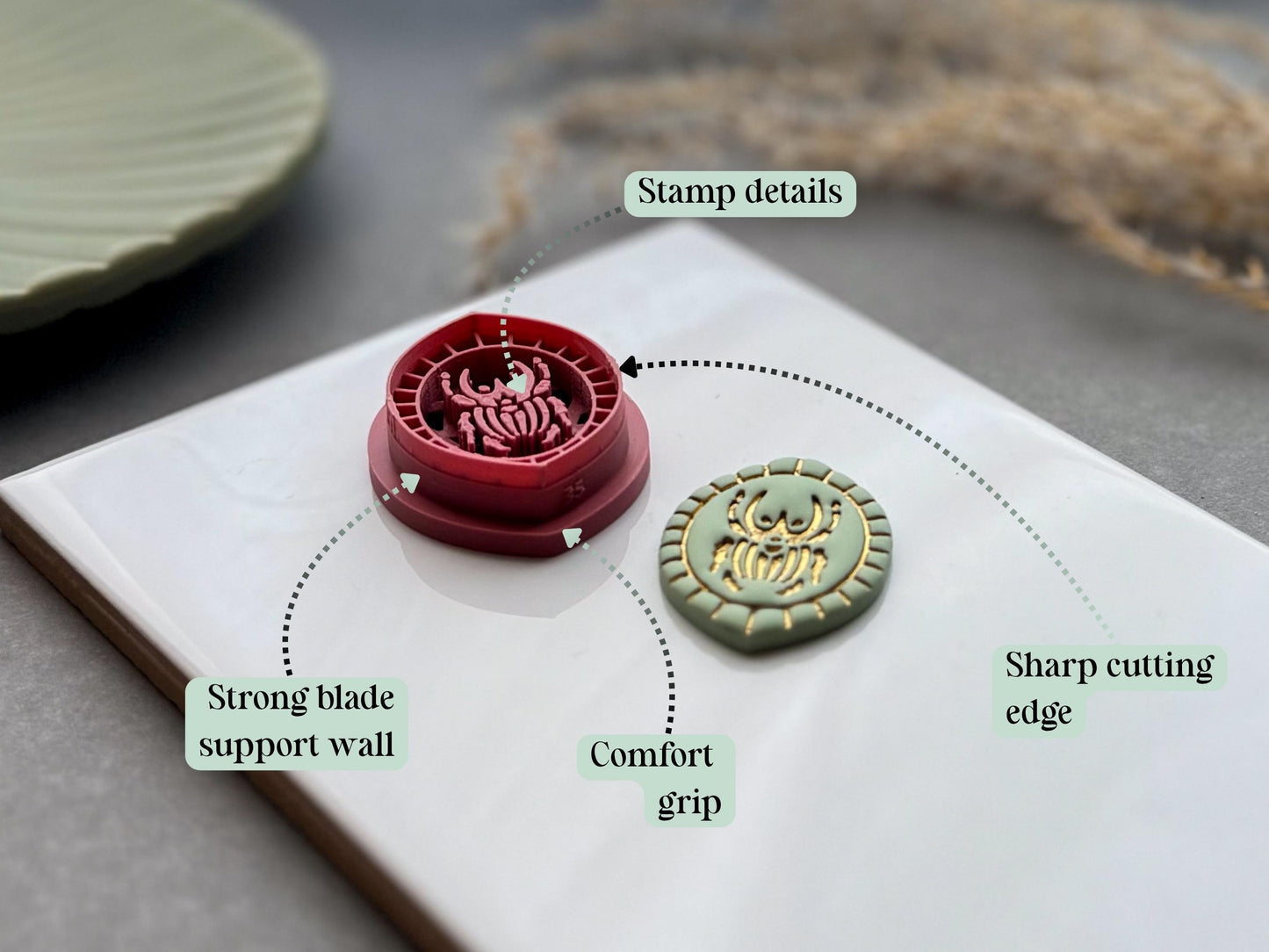 Feature graphic highlighting the Goliath beetle polymer clay cutter's detailed stamp imprint, sharp cutting edge, strong blade support wall and comfortable grip, shown beside the matching finished clay embellishment.