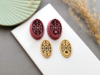 Spider web polymer clay cutters displayed alongside matching finished clay embellishments, featuring intricate web designs with and without small spiders, perfect for Halloween, gothic and spooky clay projects.