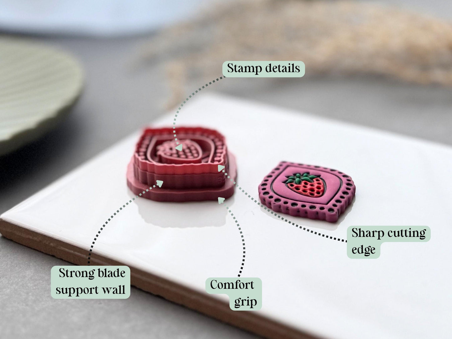 Feature graphic highlighting the strawberry frame polymer clay cutter's detailed stamp imprint, sharp cutting edge, strong blade support wall and comfortable grip, shown beside the matching finished clay embellishment.
