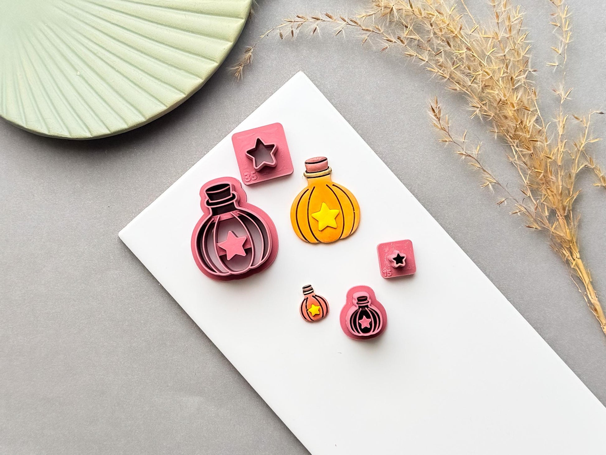 Potion bottle polymer clay cutter set with star-shaped centre designs, shown with matching finished clay pieces and small star cutters in different sizes on a white surface.