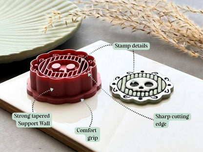 Skull frame polymer clay cutter highlighting the sharp cutting edge, comfort grip, reinforced tapered support walls and detailed embossed design, displayed alongside a finished polymer clay skull medallion sample.