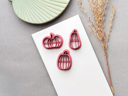 Pumpkin polymer clay cutters in three sizes, featuring segmented pumpkin designs with curved stems and internal support bars, displayed on a white surface.