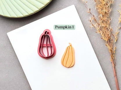 Pumpkin polymer clay cutter featuring an elongated, teardrop-shaped squash or pumpkin with a narrow rounded top and curled stem, shown alongside a finished clay pumpkin piece.
