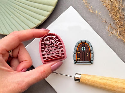 Cottagecore autumn fairy door clay cutter with an arched wooden door design, stone surround and decorative window details.