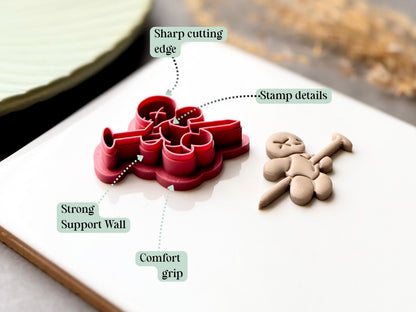 Feature graphic showing a voodoo doll clay cutter with stitched doll details and a long needle crossing through the body, alongside a finished polymer clay voodoo doll. Labels highlight the sharp cutting edge, stamp details, strong support wall and comfortable grip.