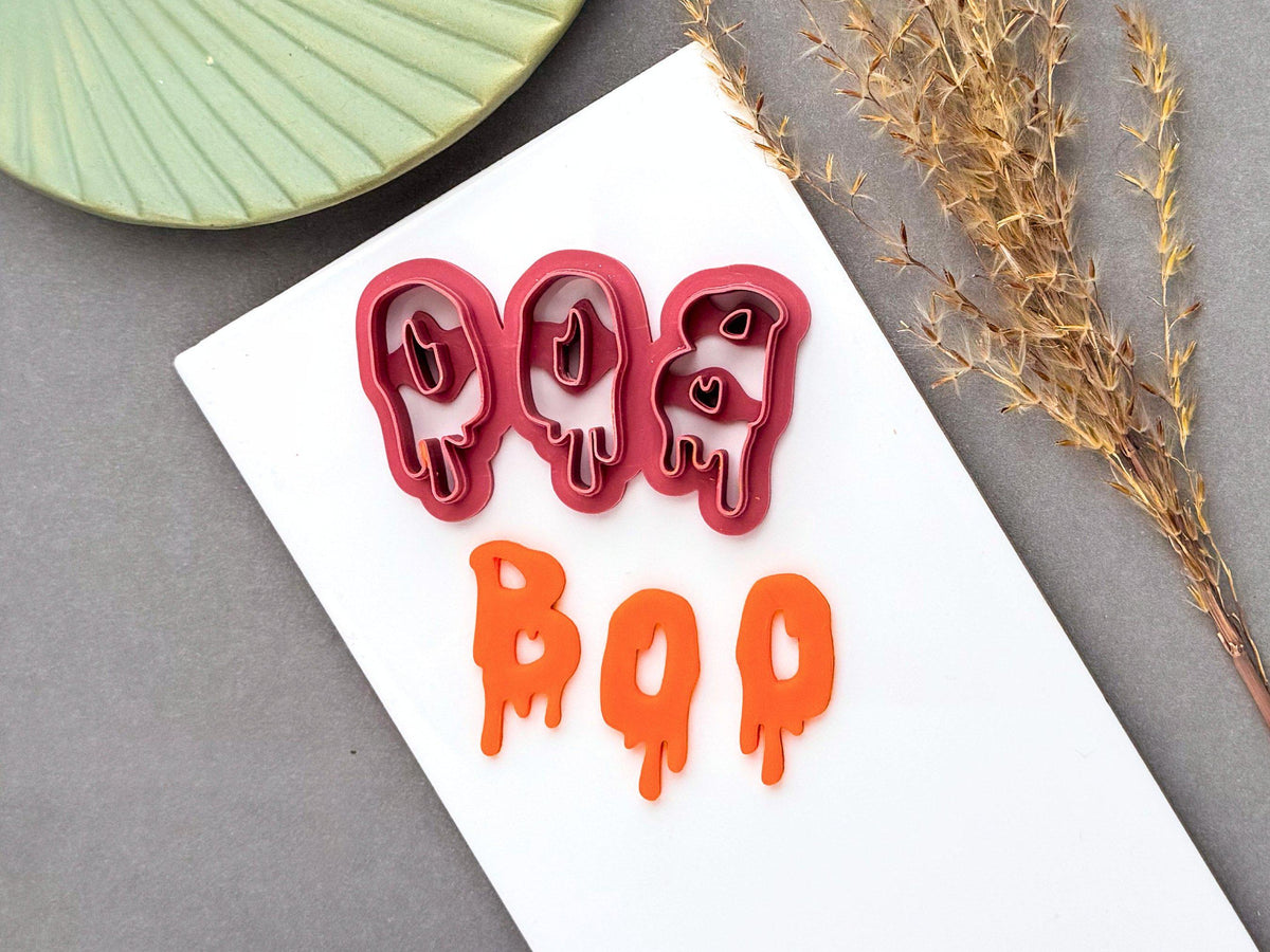 Halloween clay cutter featuring the letters “BOO” in a playful dripping slime style, shown alongside the finished orange polymer clay “BOO” design. Perfect for spooky, Halloween-themed jewellery and craft projects.